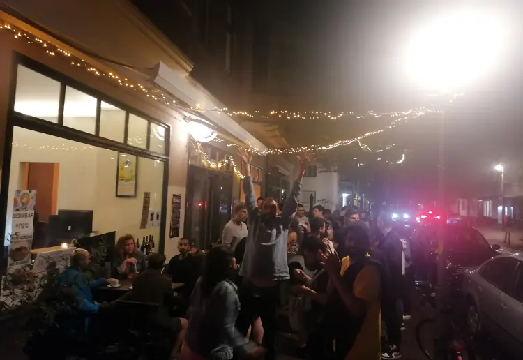 Minimalistisch eingerichteter Coworking Cafe mit Feinkostküche, großer Auswahl von Winzerweine, mit großen Fenstern und grüner Terrasse