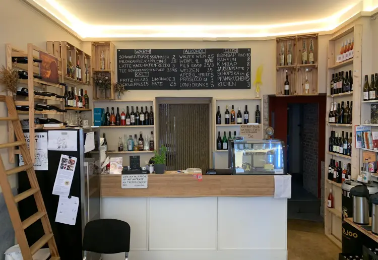 Minimalistisch eingerichteter Coworking Cafe mit Feinkostküche, großer Auswahl von Winzerweine, mit großen Fenstern und grüner Terrasse