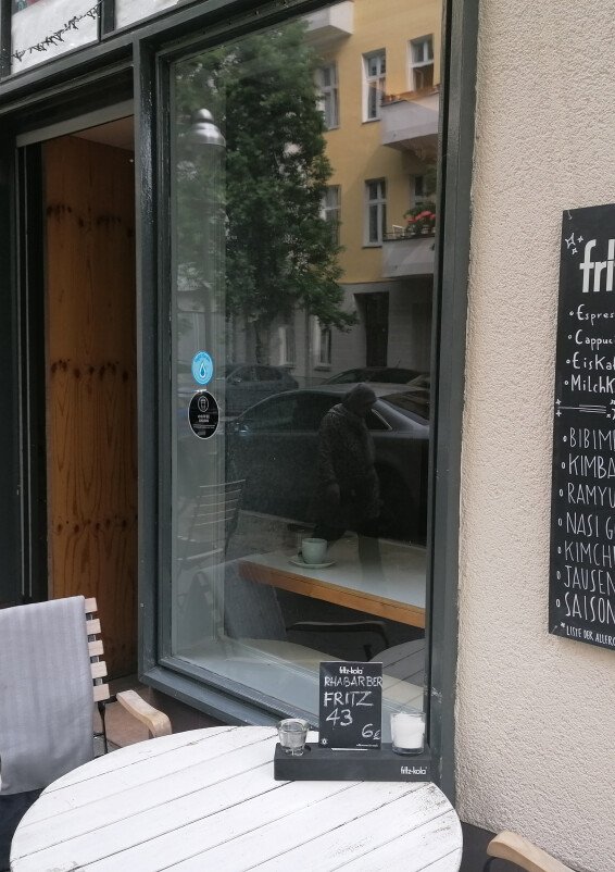 Minimalistisch eingerichteter Coworking Cafe mit Feinkostküche, großer Auswahl von Winzerweine, mit großen Fenstern und grüner Terrasse
